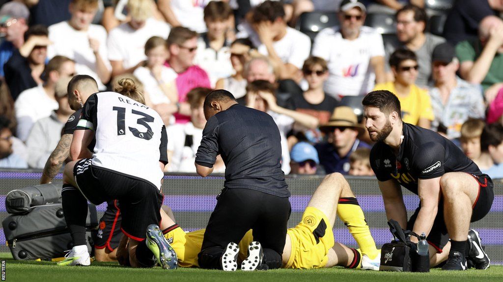 Fulham's Tim Ream consoles Sheffield United's Chris Basham after he suffers a serious injury