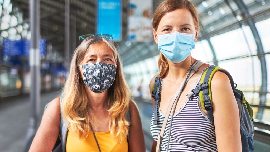 Two women travellers wearing masks