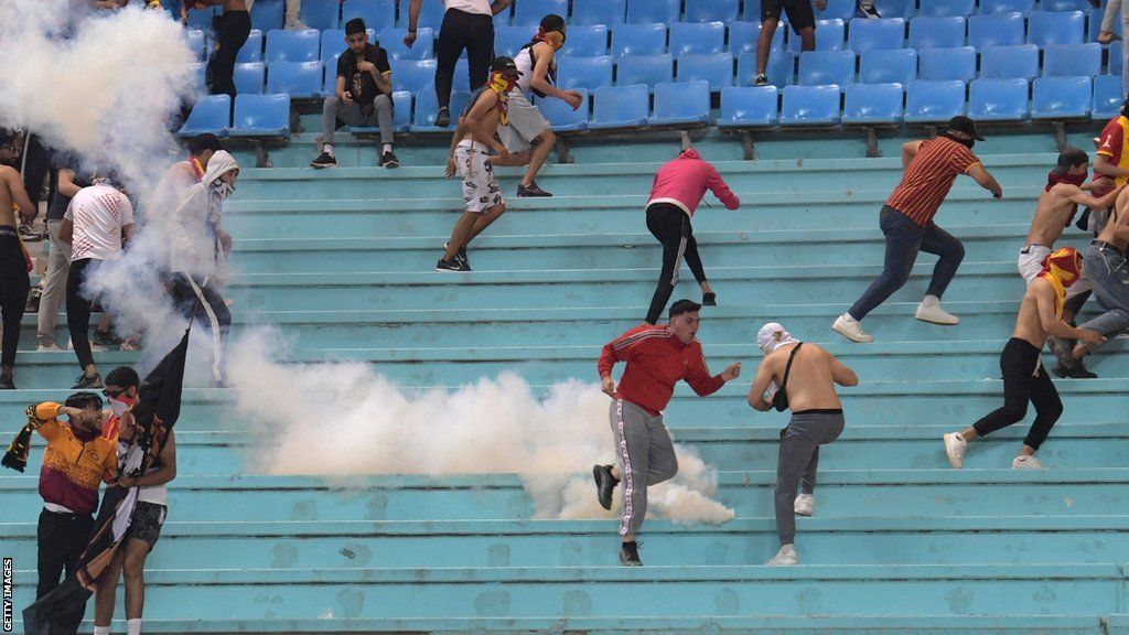 Esperance fans run from tear gas in the stand