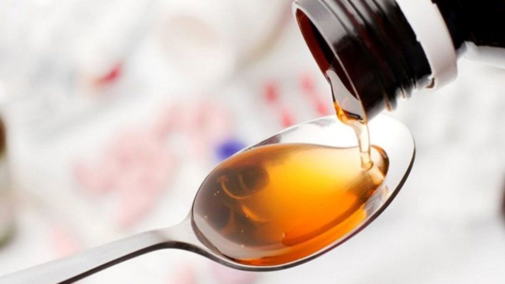 Syrup being poured into a teaspoon