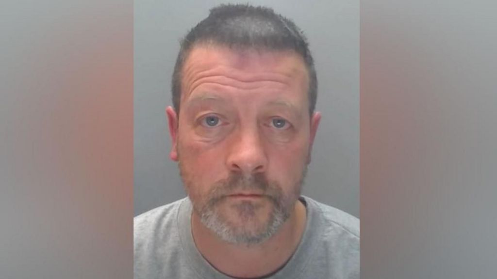 Mugshot of Simon Vickers. He has short dark hair, a grey beard and is wearing a grey sweatshirt.