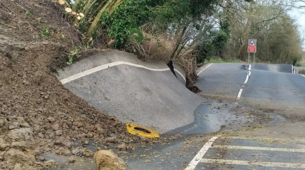 Lyneham Banks landslip causing the road to buckle and sit diagonally against the bank