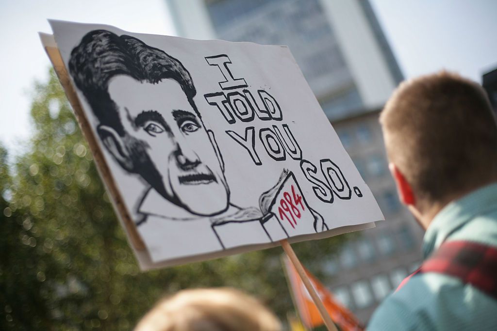 Protest banner of Orwell holding a copy of 1984