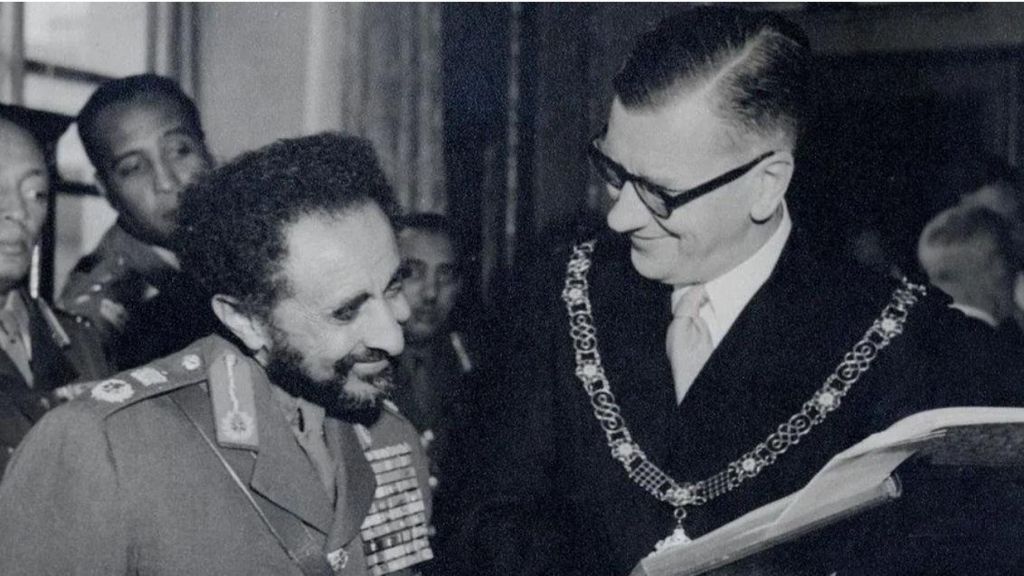 A black and white photo of Emperor Haile Selassie with the Mayor of Bath William Gallop. Both are in their unfirms and are smiling.