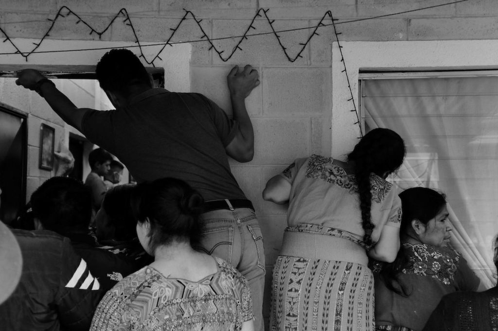 Family members and neighbours of Baltazar Gomez Toma watch as members of the Forensic Anthropology Foundation of Guatemala (FAFG) arrange his skeletal remains. Cotzal, Quiche, Guatemala. February 10, 2021.