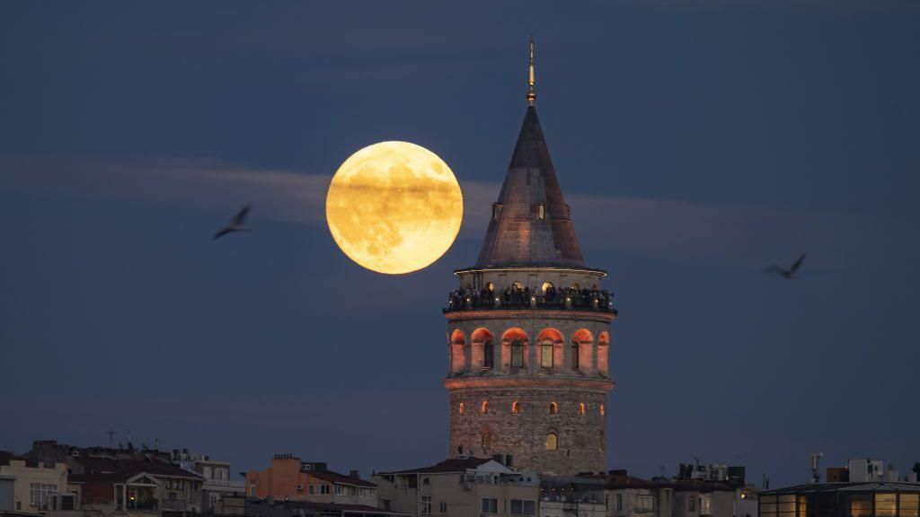 Full Moon rises behind the Galata Tower in Istanbul, Turkiye