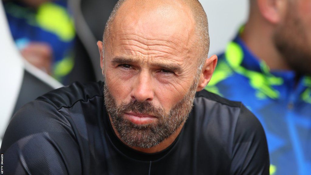 Paul Warne sits in the dugout before Derby's friendly with Sheffield United