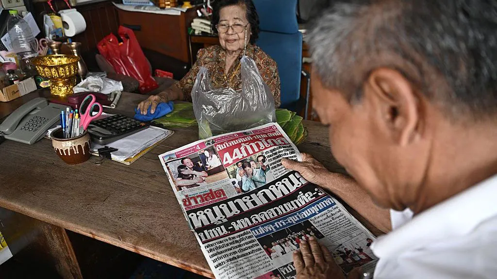 A shopkeeper reads the front page of Khaosod newspaper a day after the general election in Bangkok on February 9, 2026