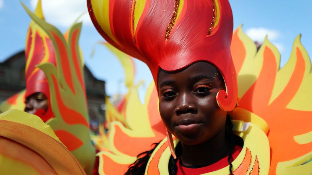 A girl wears a red and orange costume that appears to look like flames.