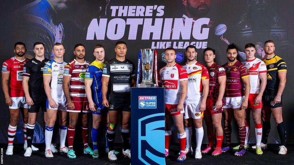 Super League players stand by the trophy for a promotional photograph
