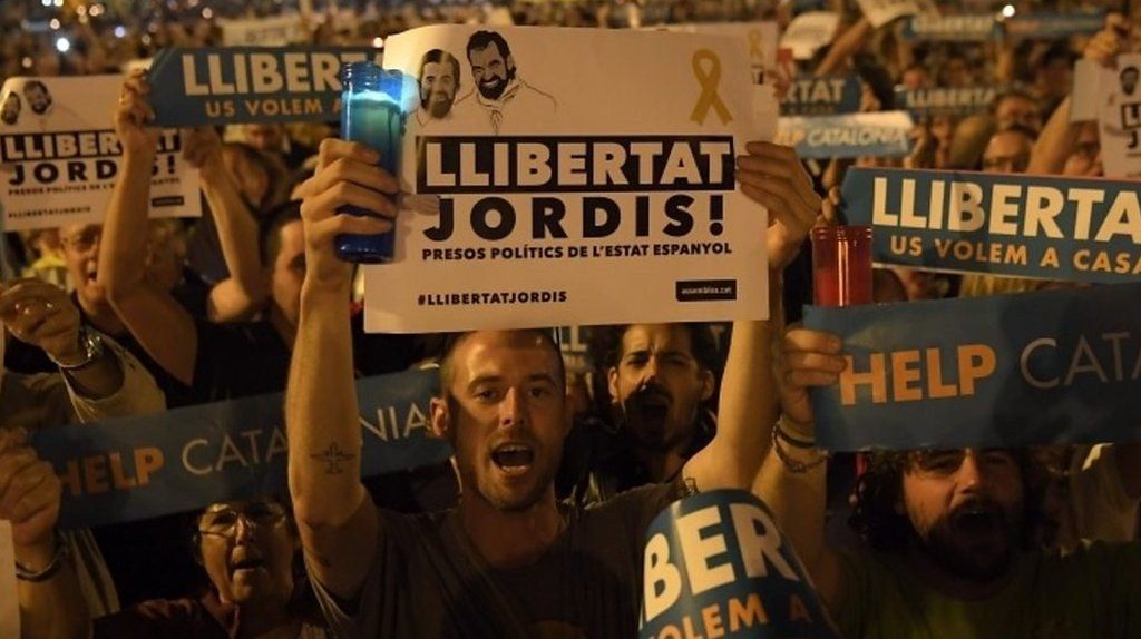 People hold placards reading "Freedom" during candlelit demonstration in Barcelona