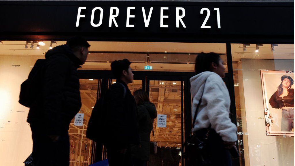 People walking past a closed Forever 21 store