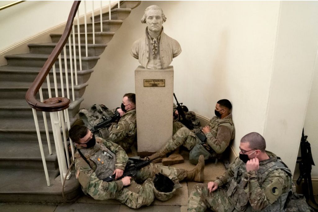 Soldiers rest against statue of George Washington