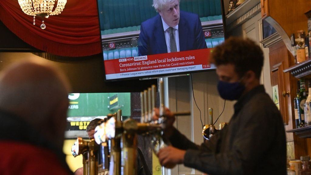 A man pours a pint whilst Boris plays in the background