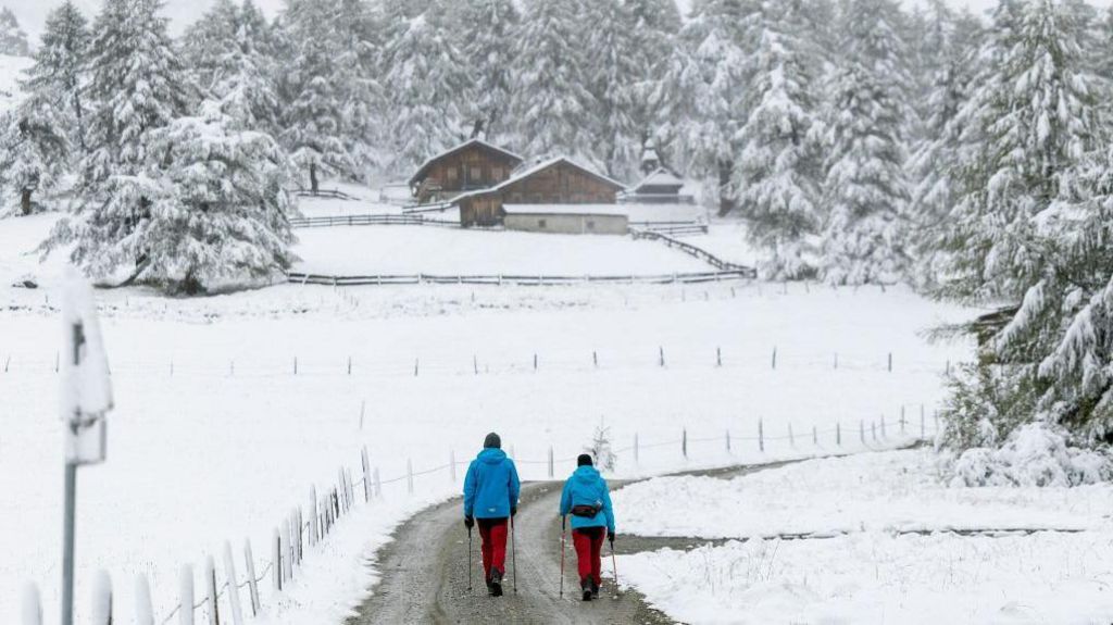 Hikers walk through the snow-covered landscape at the Kalser Ködnitztal valley in Kals am Grossglockner, Tyrol, Austria, on September 13, 2024