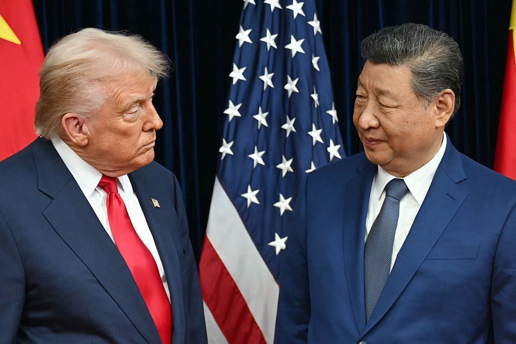 US President Donald Trump (L) and China's President Xi Jinping, noth in dark suits, size each other up with heads cocked, as they arrive for talks at the Gimhae Air Base, located next to the Gimhae International Airport in Busan on October 30, 2025. 