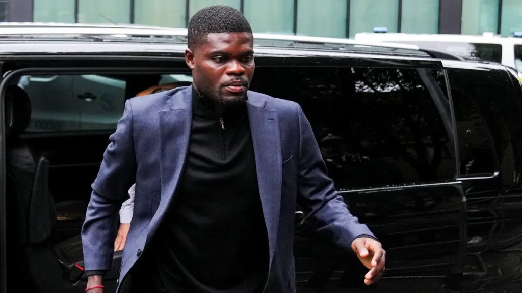 Thomas Partey walks towards the camera as he exits a car