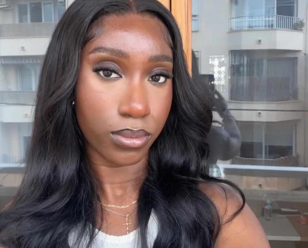 Theresa a 24-year-old woman taking a selfie with a neutral expression