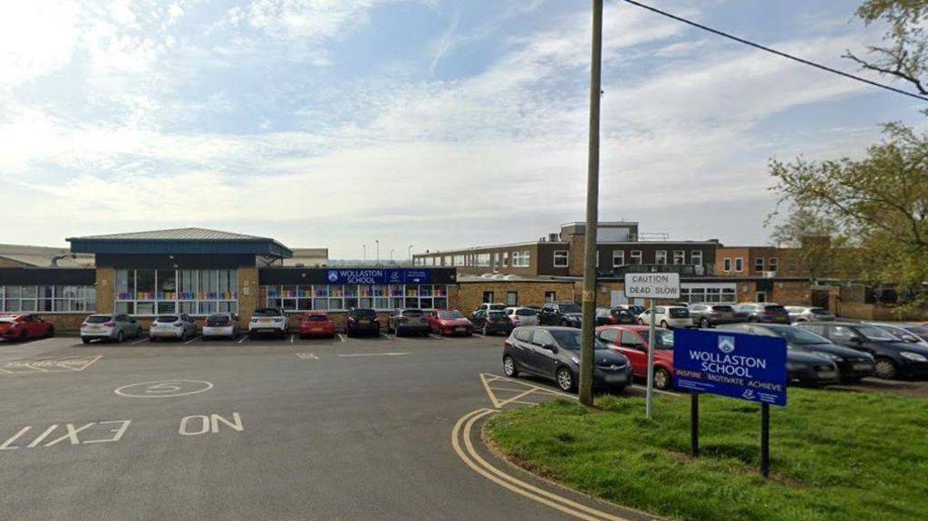 Entrance to a 1950s school with car park in front