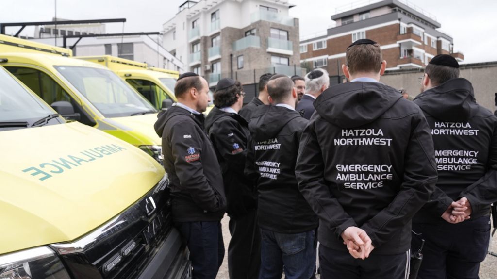Staff from Hatzola Northwest Emergency Ambulance Service stand alongside the four replacement ambulances
