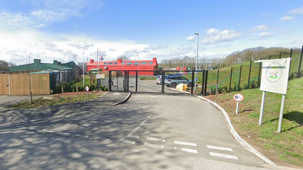 The school gates in front of a bright red school building