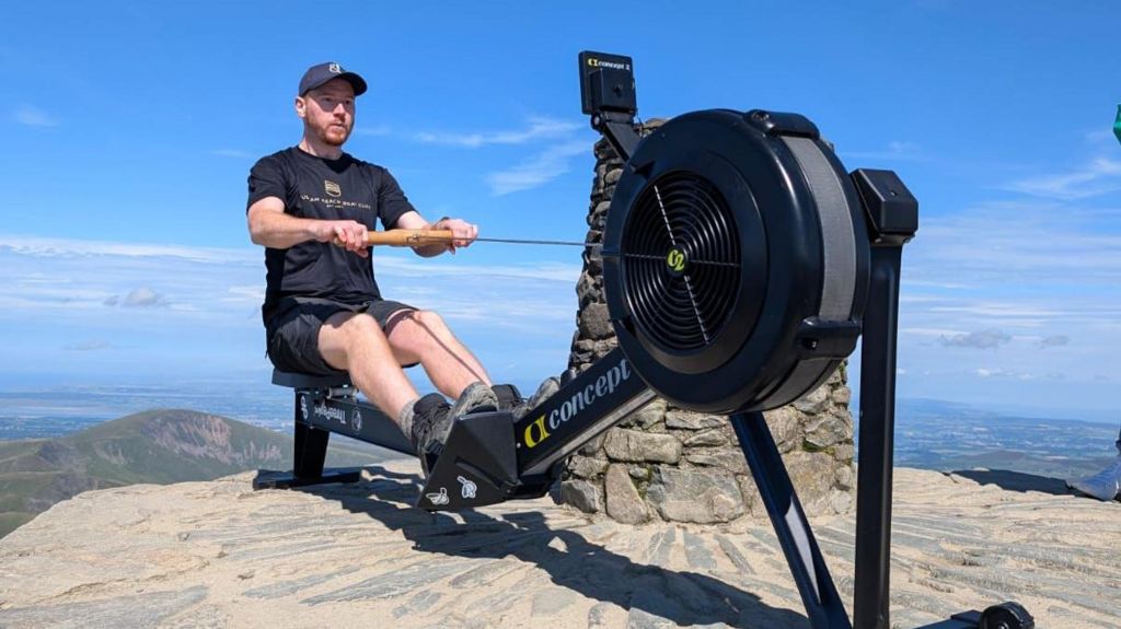 Scott Brown using a rowing machine at the top of Yr Wyddfa