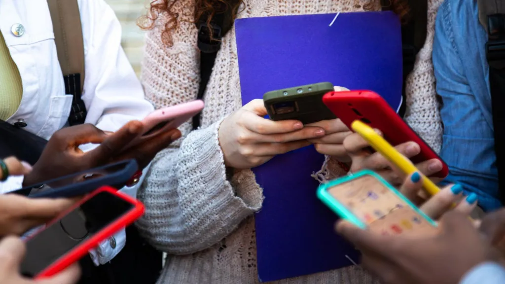 Hands of teenage girls on mobile phones