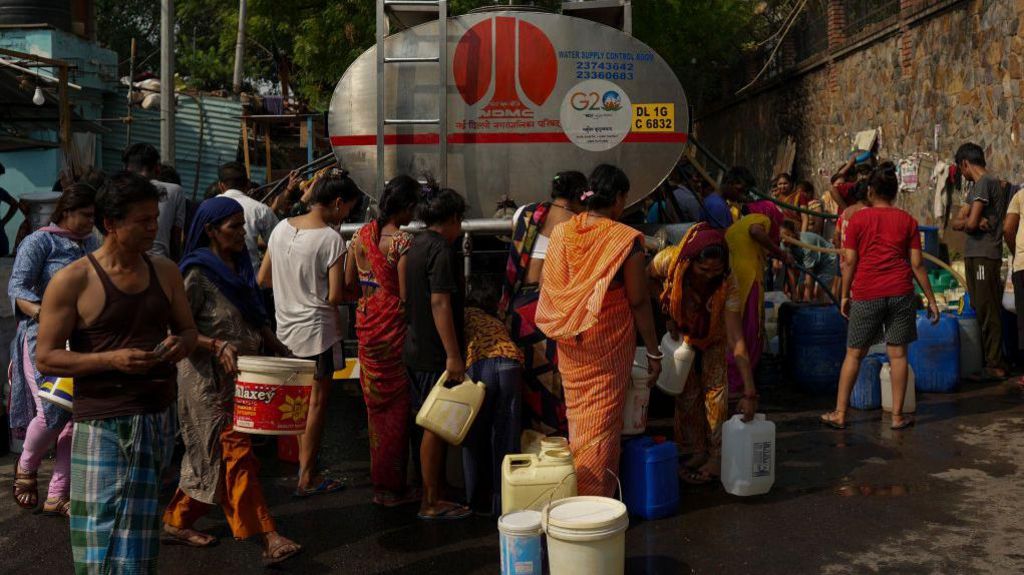 NEW DELHI, INDIA - MAY 22: People gather around a municipal tanker to collect water during high temperatures in New Delhi, India, on May 22, 2024. (Photo by Amarjeet Kumar Singh/Anadolu via Getty Images)