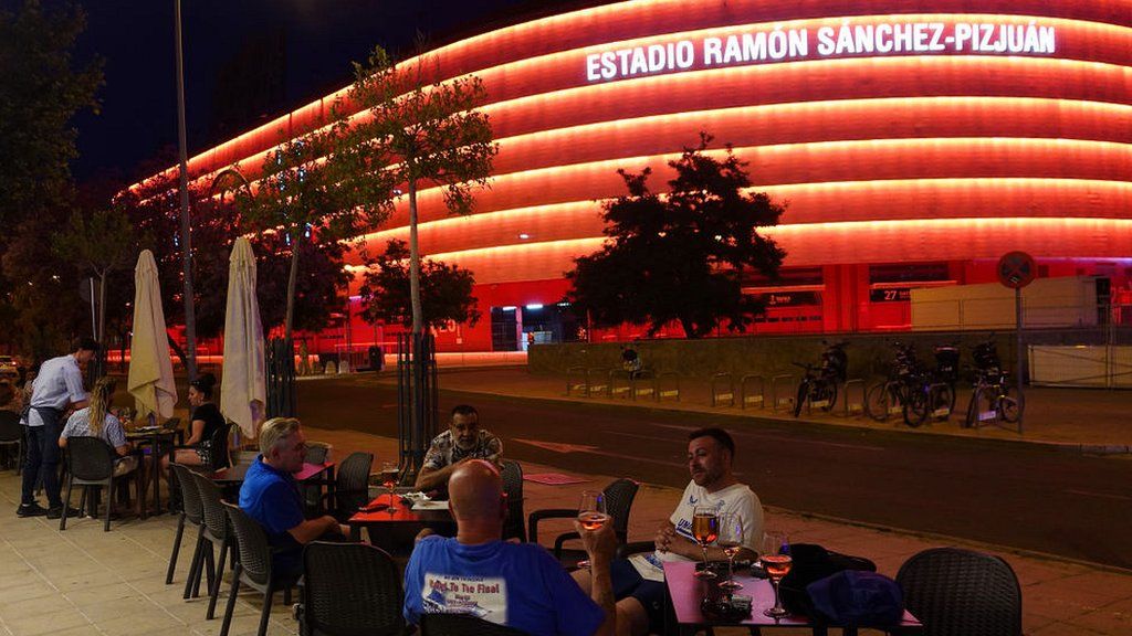 Rangers fans drink at tables close to the stadium hosting the final