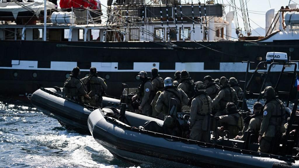 Members of French National Gendarmerie Intervention Group (GIGN) guard the French 19th-century three-masted Belem as it sails in the bay of Marseille, in the Mediterranean Sea, on May 8, 2024