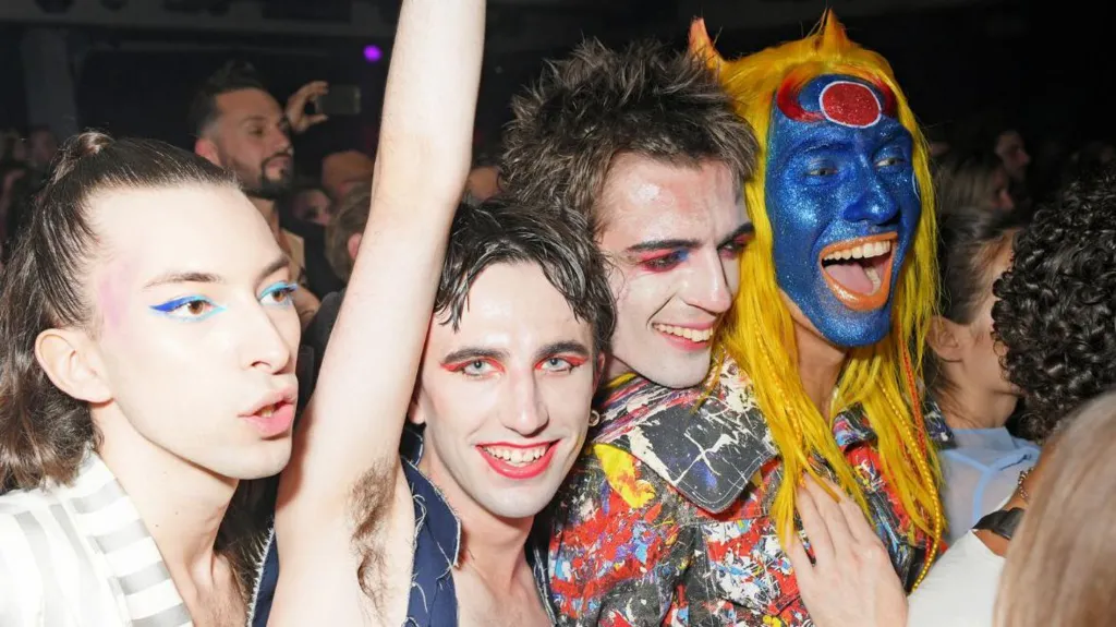 Charles Jeffrey sporting a painted denim look with blue face-paint, he is out clubbing with friends.