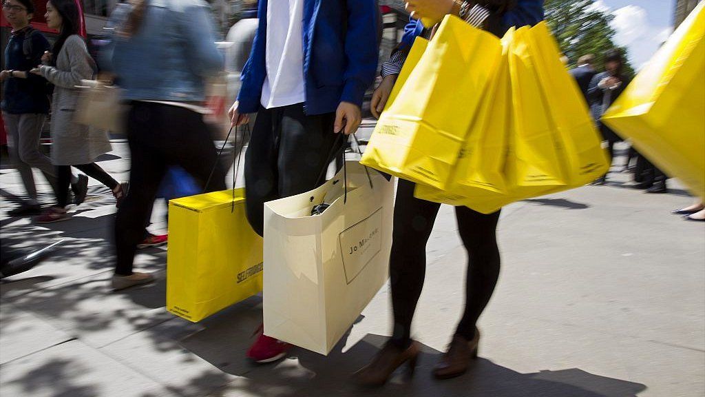 Shoppers carry bags from a Selfridges store