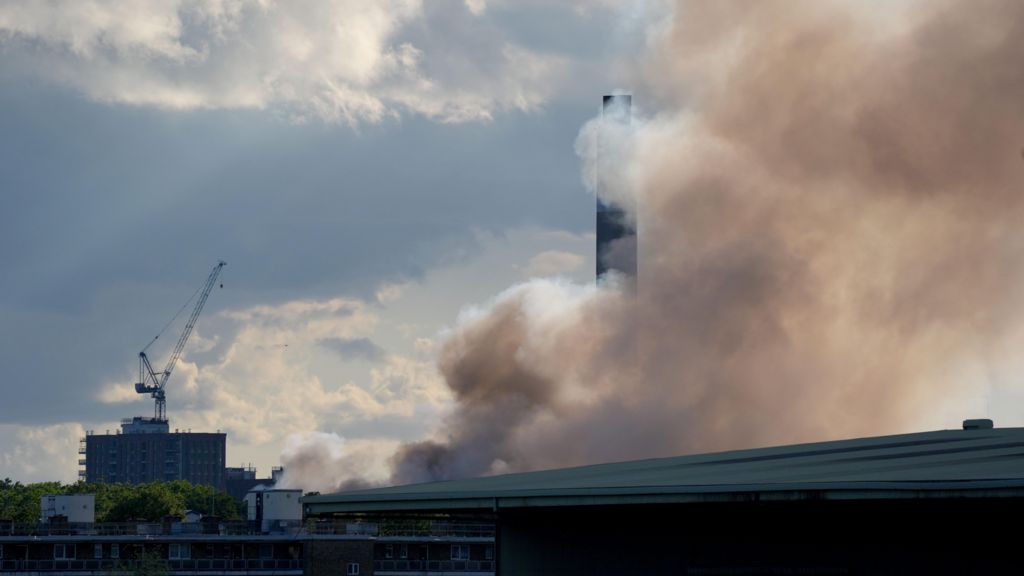 A view from Masthouse Terrace boat stop, on the Isle of Dogs as smoke rises into the sky from a fire at the Landmann Way Reuse and Recycling Centre in Bermondsey, south London