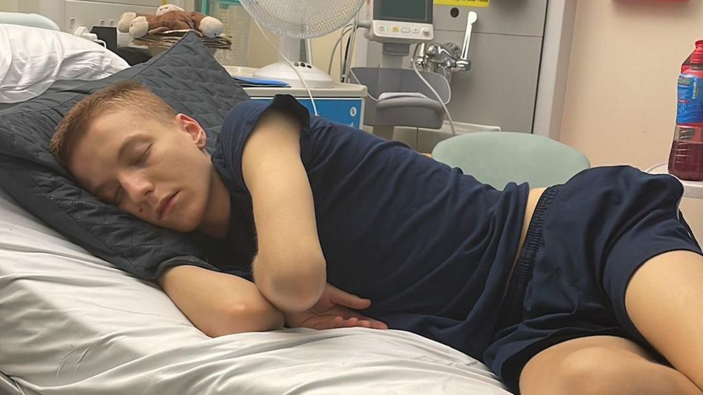 Boy lying in hospital bed 