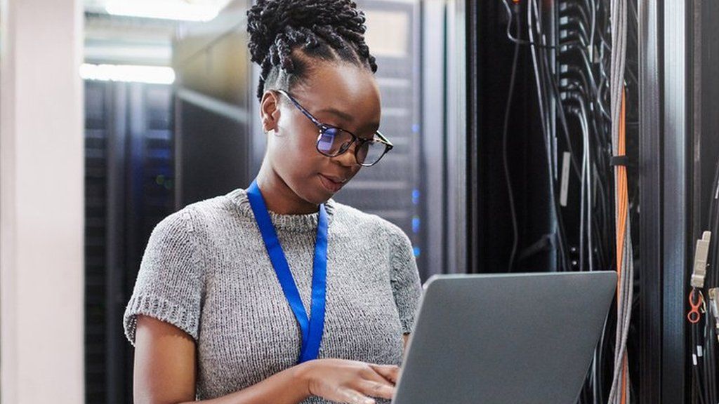 a black woman working in a server room