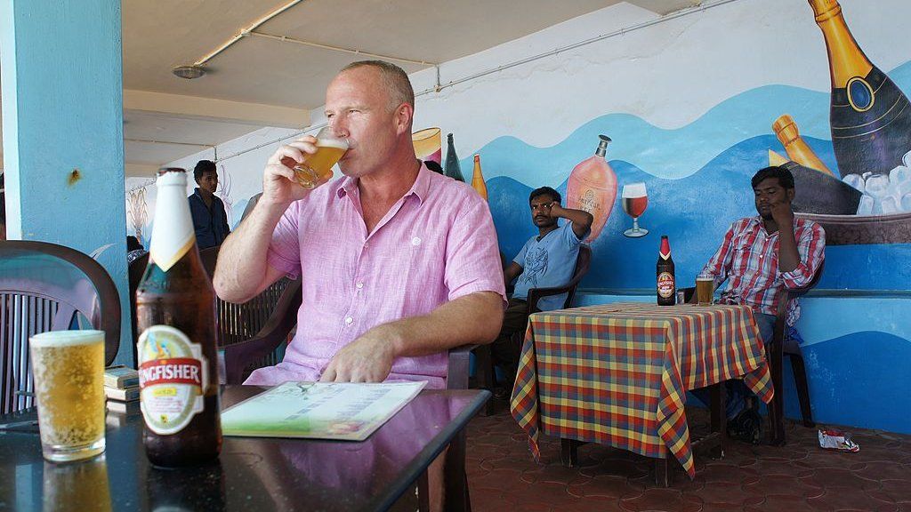 British tourist John Packer, a 41-year-old tiler, drinks a beer at a seafront restaurant in the resort town of Kovalam, in southern Kerala state on 9 September 2014