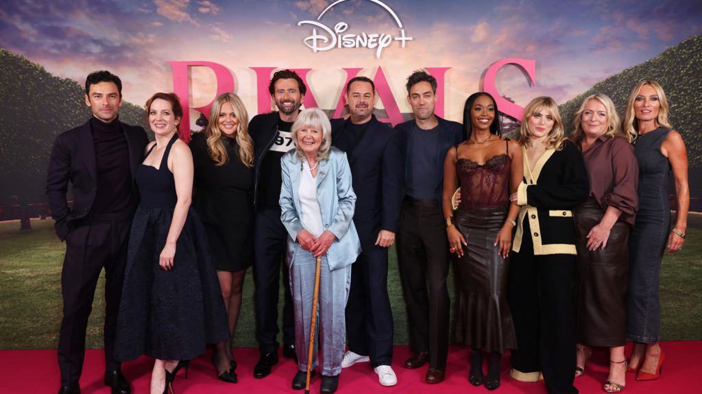 Dame Jilly Cooper surrounded by members of the cast of Disney+'s adaptation of Rivals in 2024