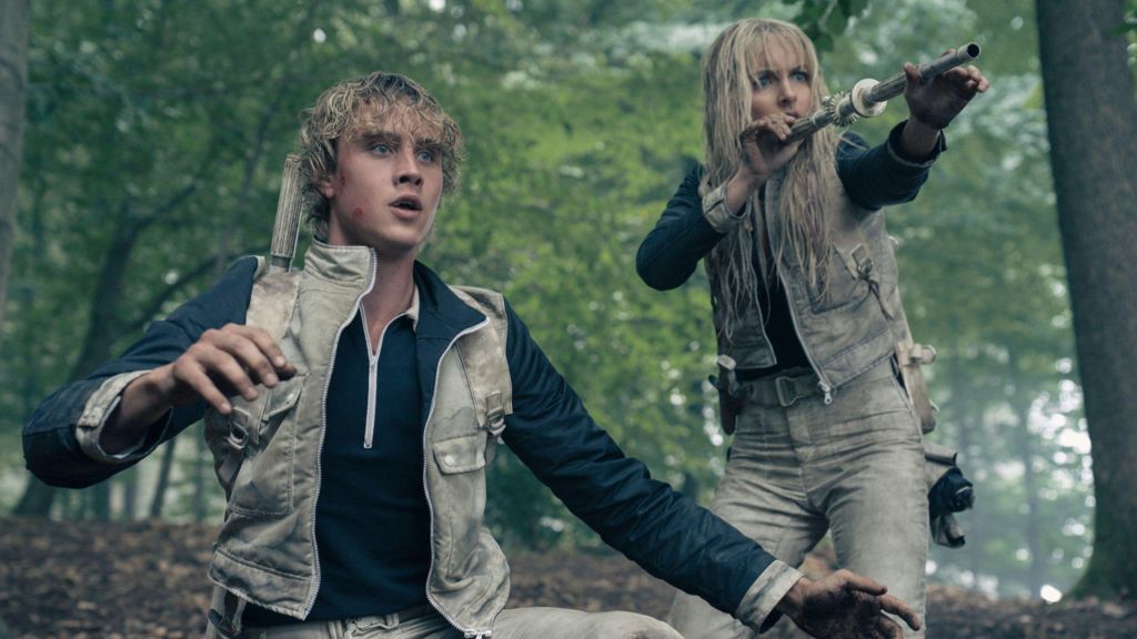 Joseph Zada as Haymitch Abernathy and McKenna Grace as Maysilee Donner in a forest scene from the film 