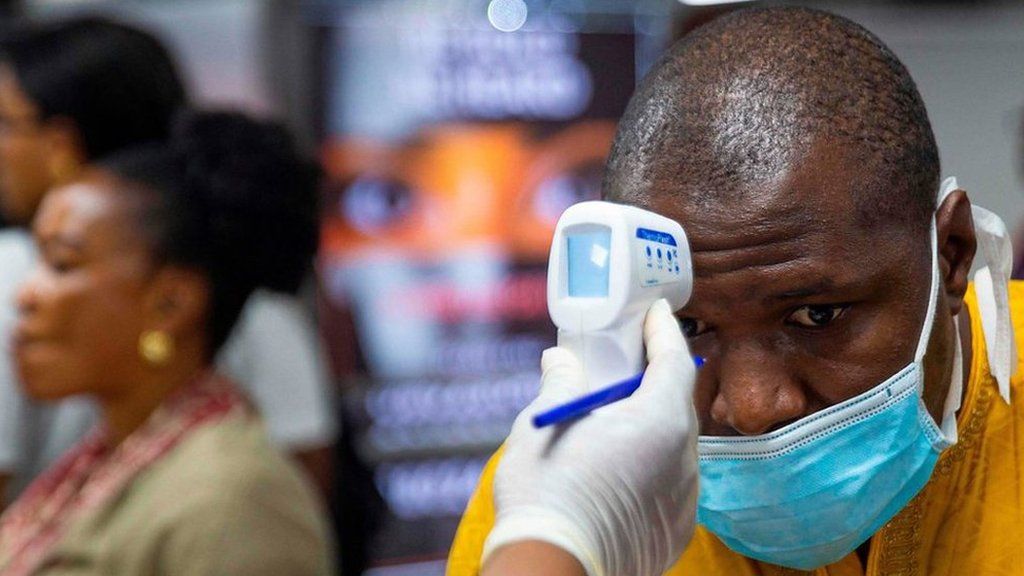 A passenger"s body temperature is being tested at the gate of entry upon arrival at the Murtala International Airport in Lagos