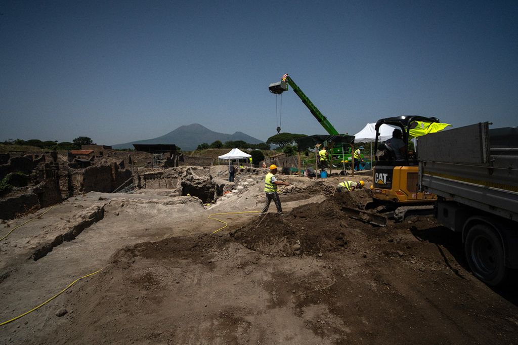 Excavation work under way in the searing summer heat, in the shadow of Mount Vesuvius