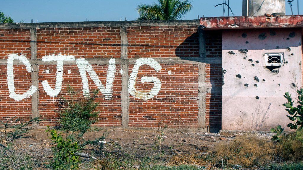 View of a bullet-riddled wall bearing the initials of the criminal group Cartel Jalisco Nueva Generacion (CJNG) at the entrance of the community of Aguililla, state of Michoacan, Mexico, on April 23, 2021.