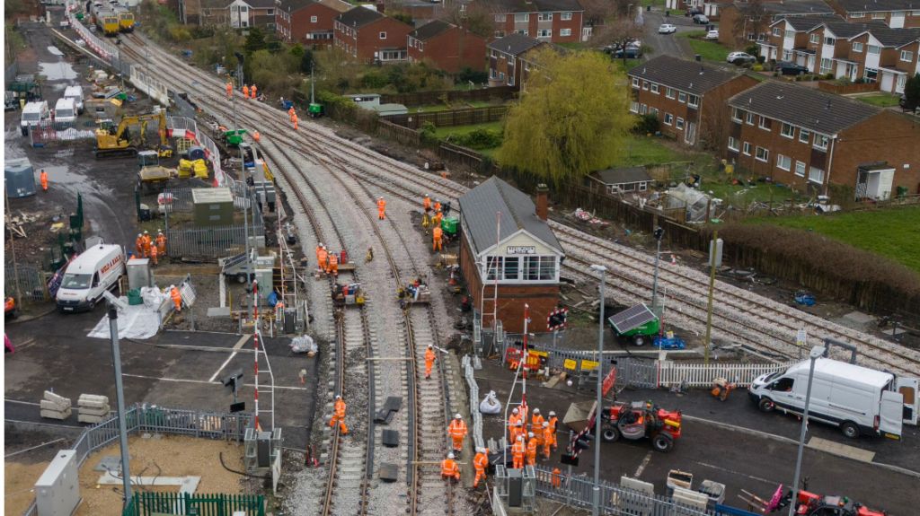 A picture of men working at a busy level crossing