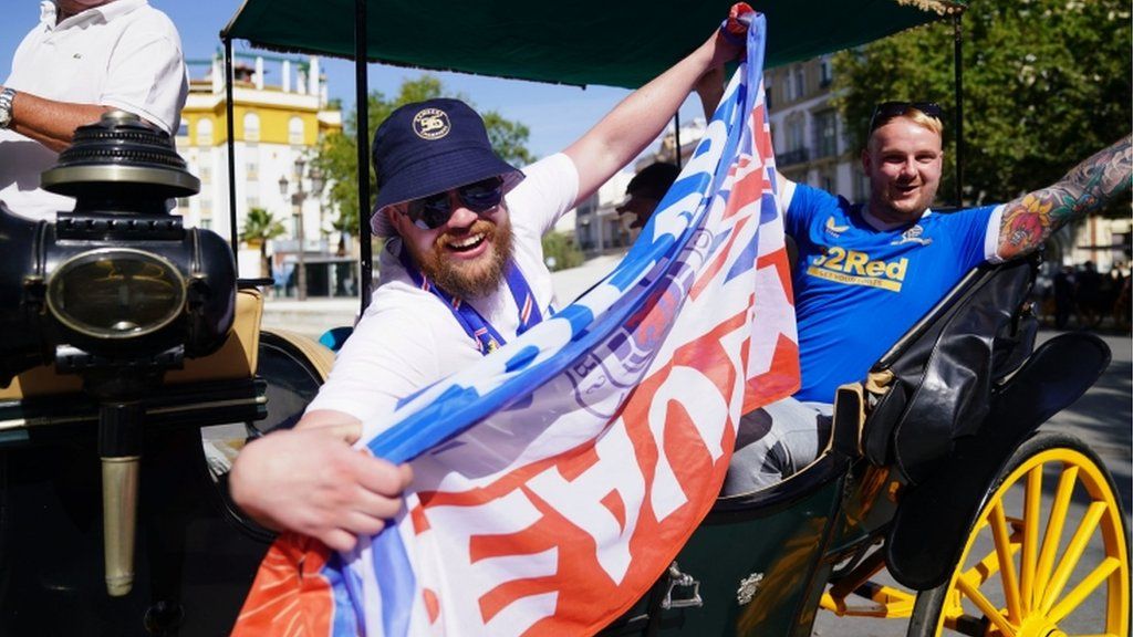Rangers fans with a flag enjoy a carriage ride around Seville