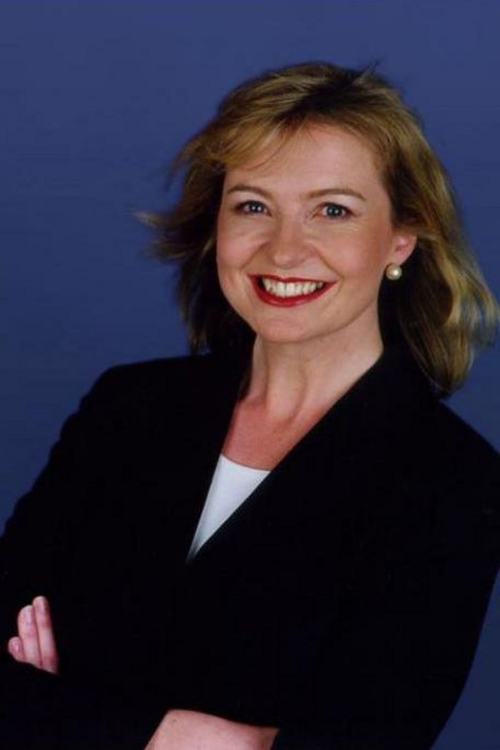 Carol Kirkwood in 2002, smiling with her arms crossed.