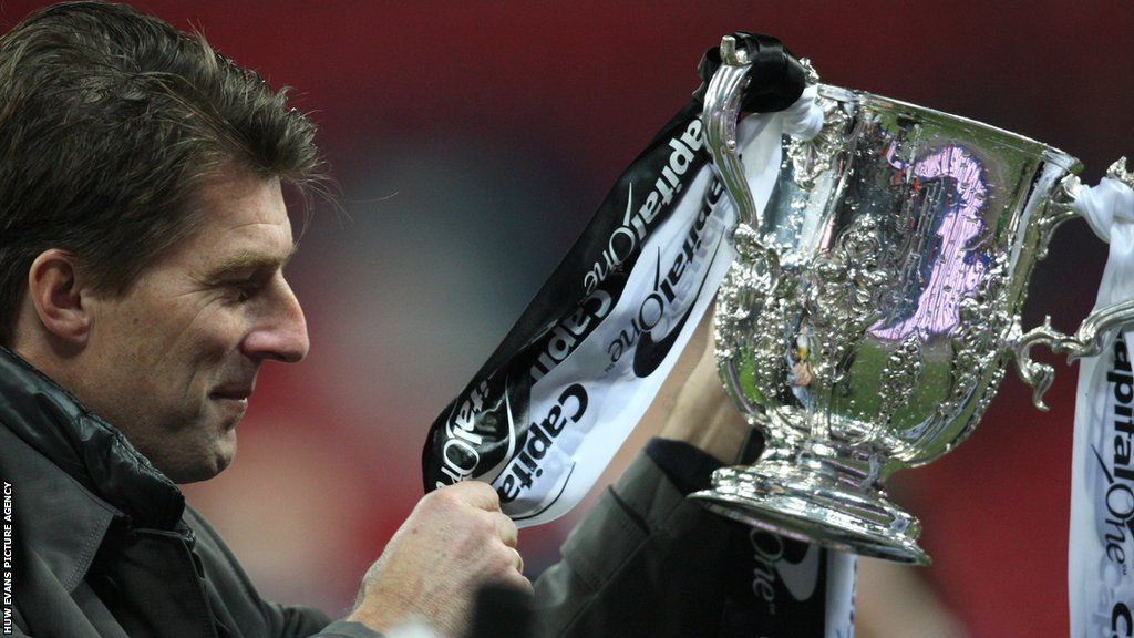 Michael Laudrup looks at the Capital One Cup trophy