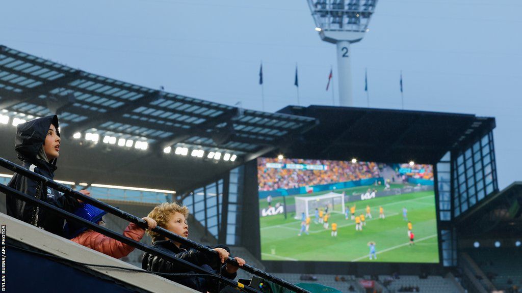 Fans arrive early to watch the Matildas match against France on the big screens before the 2023 AFL match between the Carlton Blues and the Melbourne Demons at Melbourne Cricket Ground