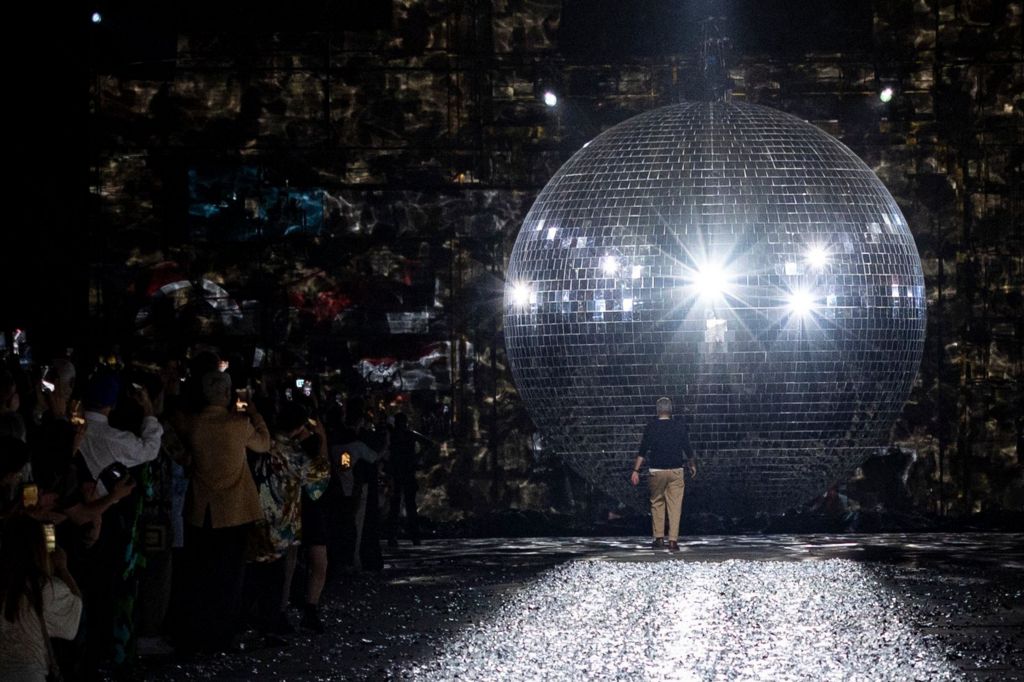 Designer Dries Van Noten walks towards giant disco ball paris fashion week