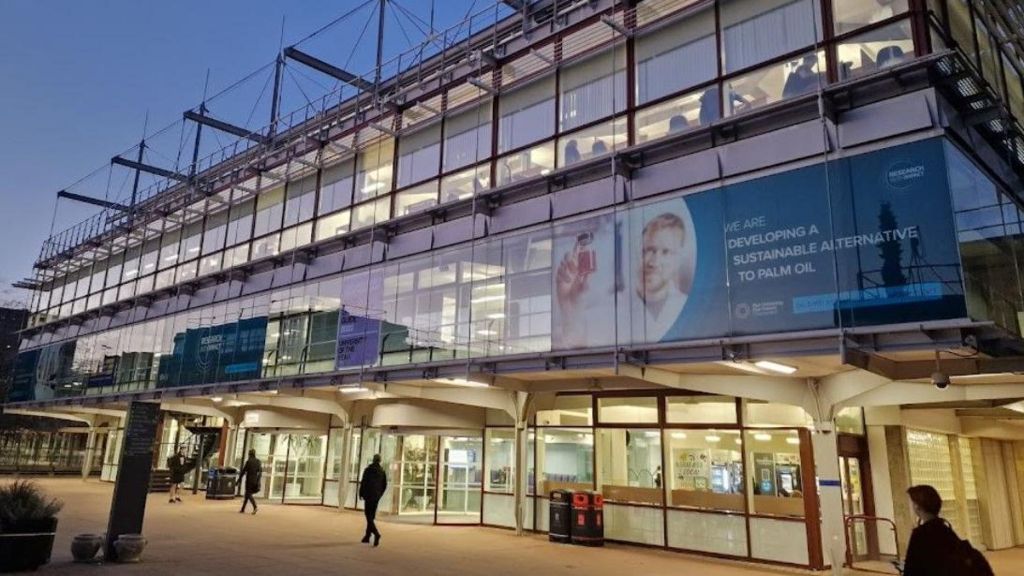 A glass building with people walking outside it