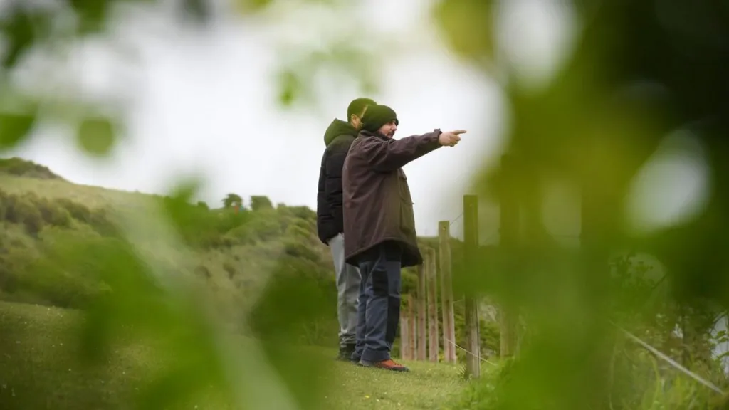  Amar Hussein is pointing at something out of view of the camera while Walid Saadaoui stands behind him in Dover, Kent