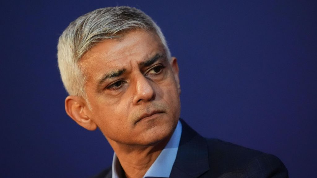Mayor of London Sir Sadiq Khan, pictured against a dark blue background, speaking at an event in London.